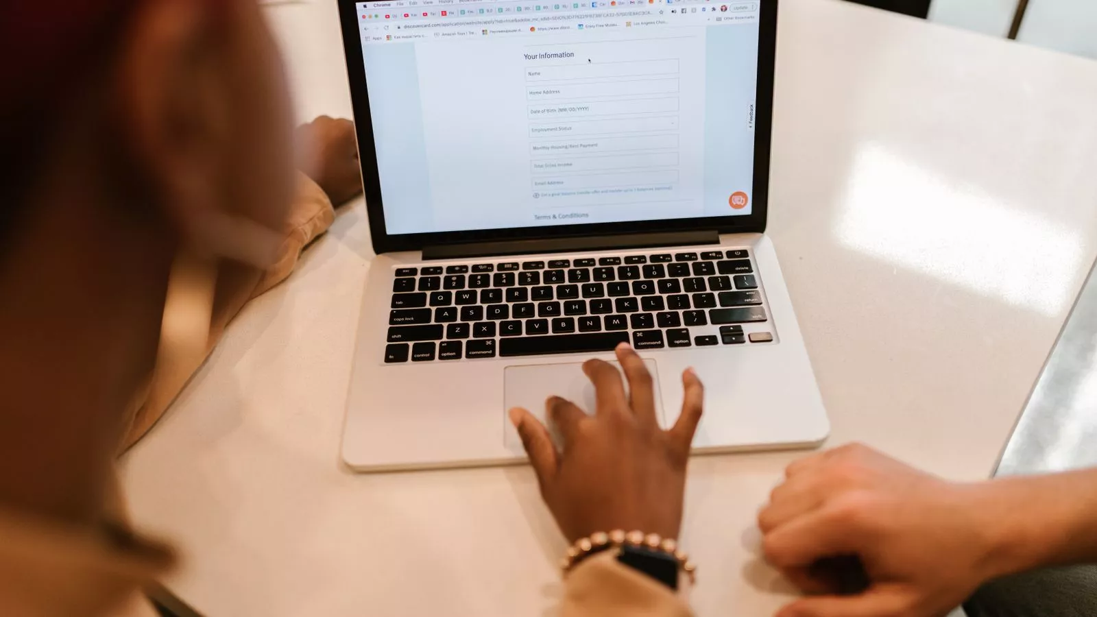 Twee mensen vullen samen een online formulier in op een laptop